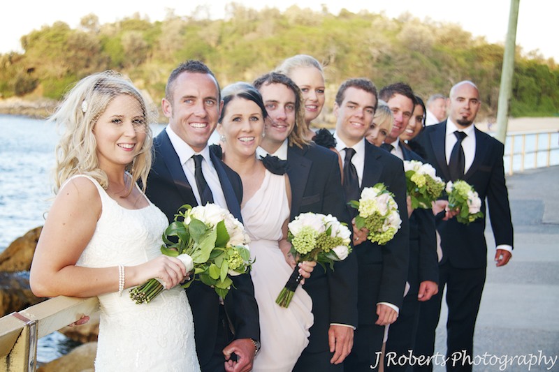 Bridal party all smiles along the railing at Shelley Beach Manly - wedding photography sydney
